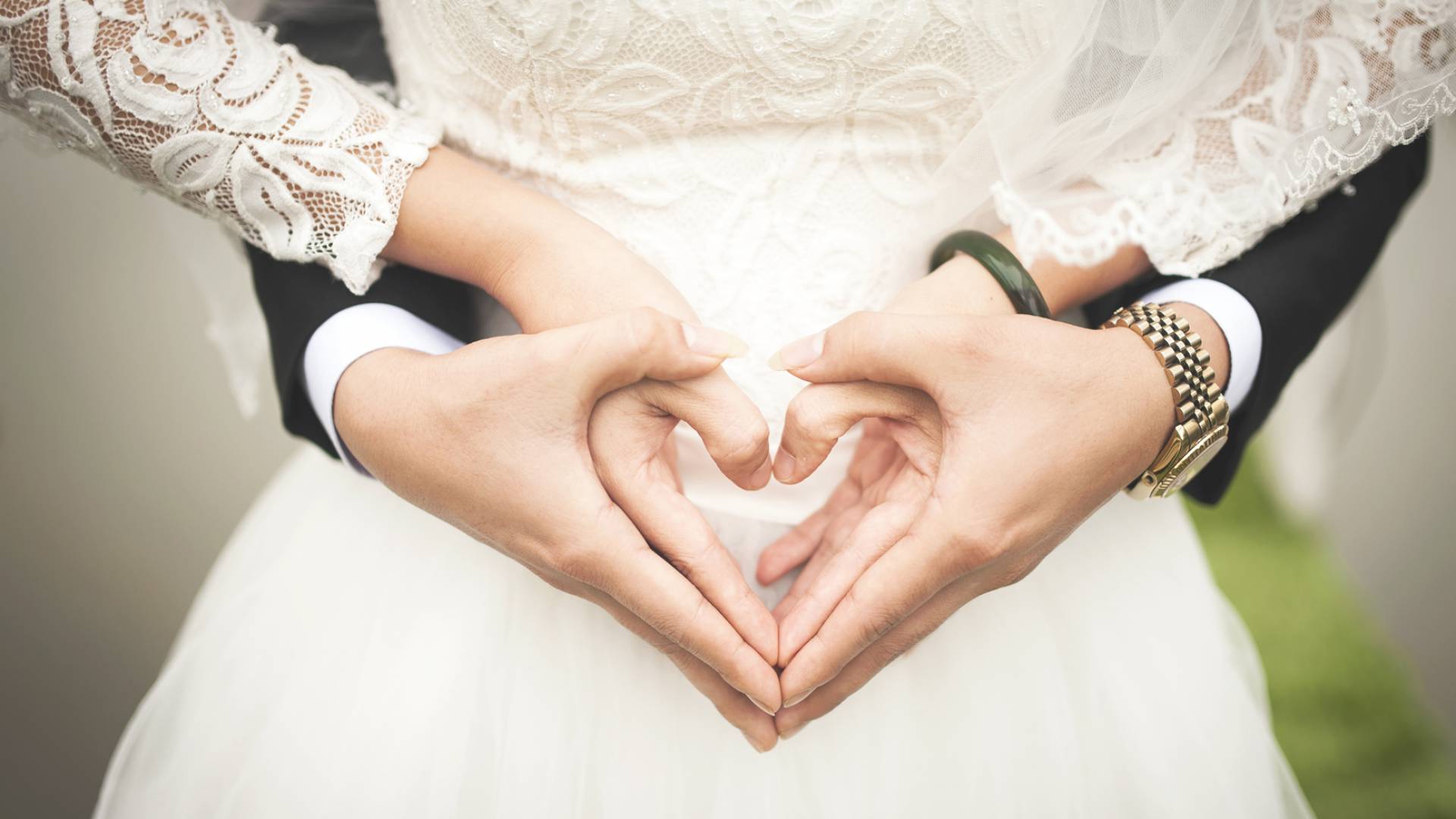 Brautpaar formt ein Herz mit ihren Händen