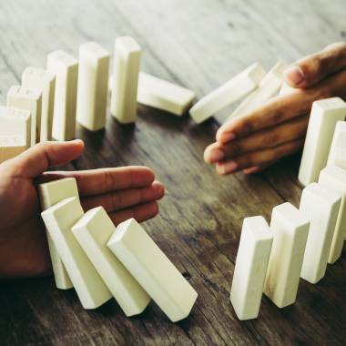 Menschen bauen Dominosteine auf