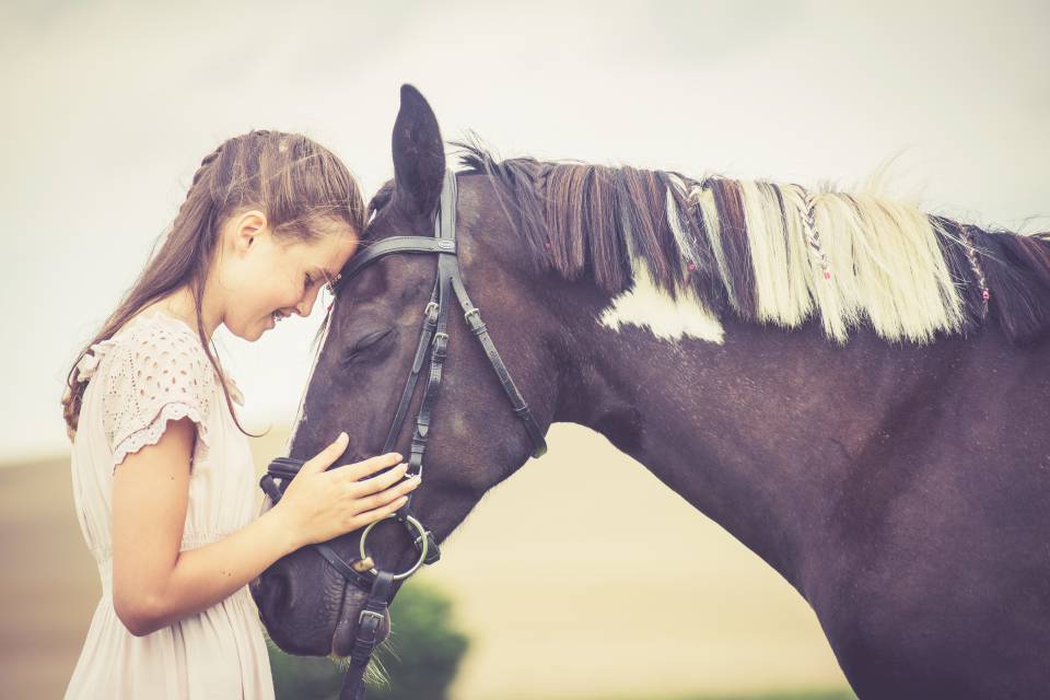 Kind schmust mit Pferd