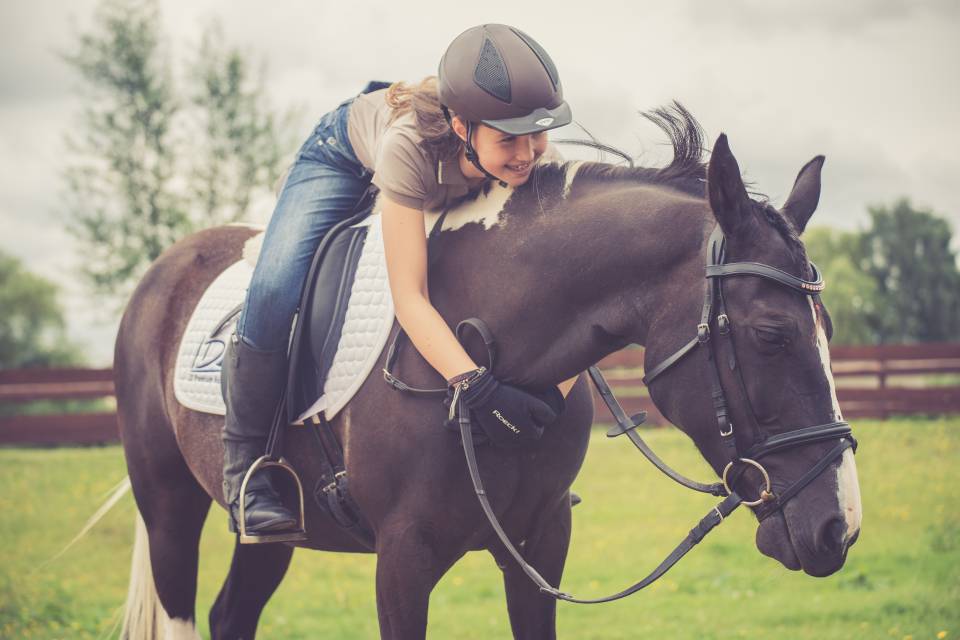 Mädchen sitzt auf Pferd