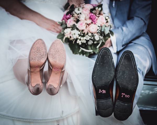 Hochzeitspaar zeigt Brautschuhe in die Kamera