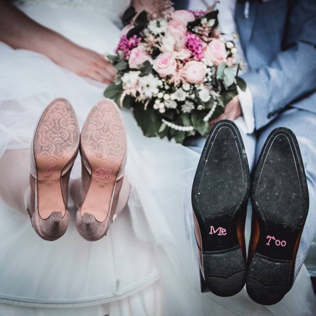 Hochzeitspaar zeigt Brautschuhe in die Kamera