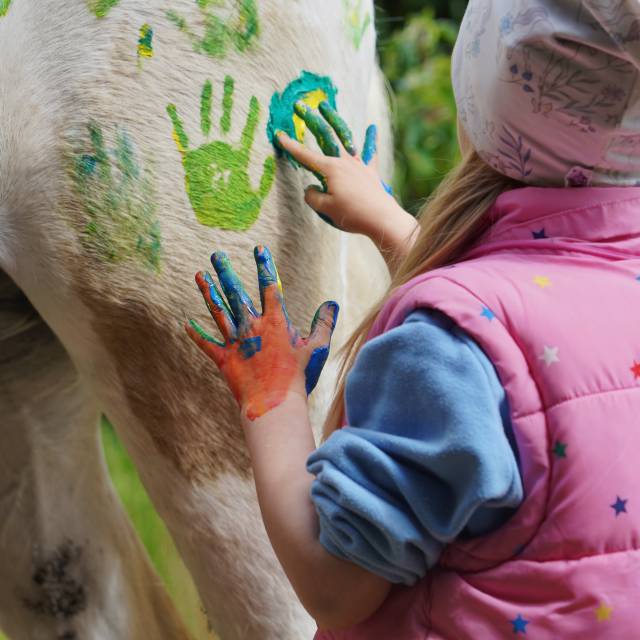 Kind bemalt Pferd mit Fingerfarbe