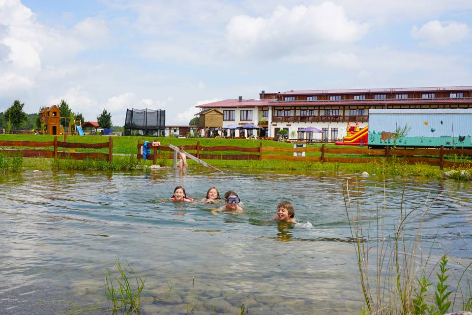 Kinder schwimmen in Naturbadeteich