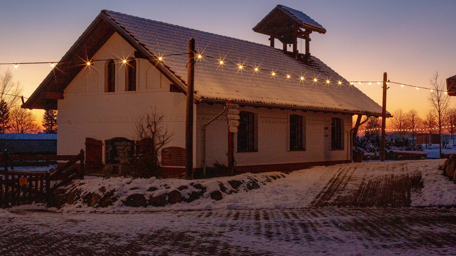 Beleuchtete Hofkirche im Winter auf dem verschneiten Golchener Hof